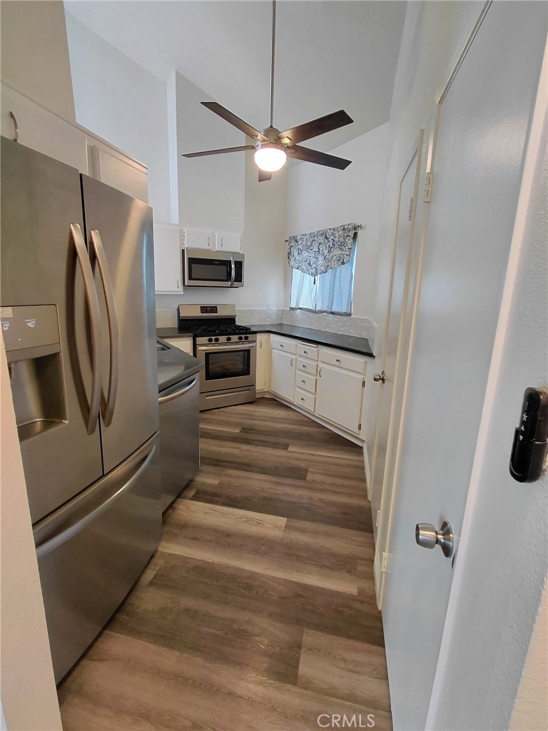 14530 Nautical Lane, Unit 15 Helendale, CA 92342 - Photo 3 of 14 a kitchen with cabinets and stainless steel appliances