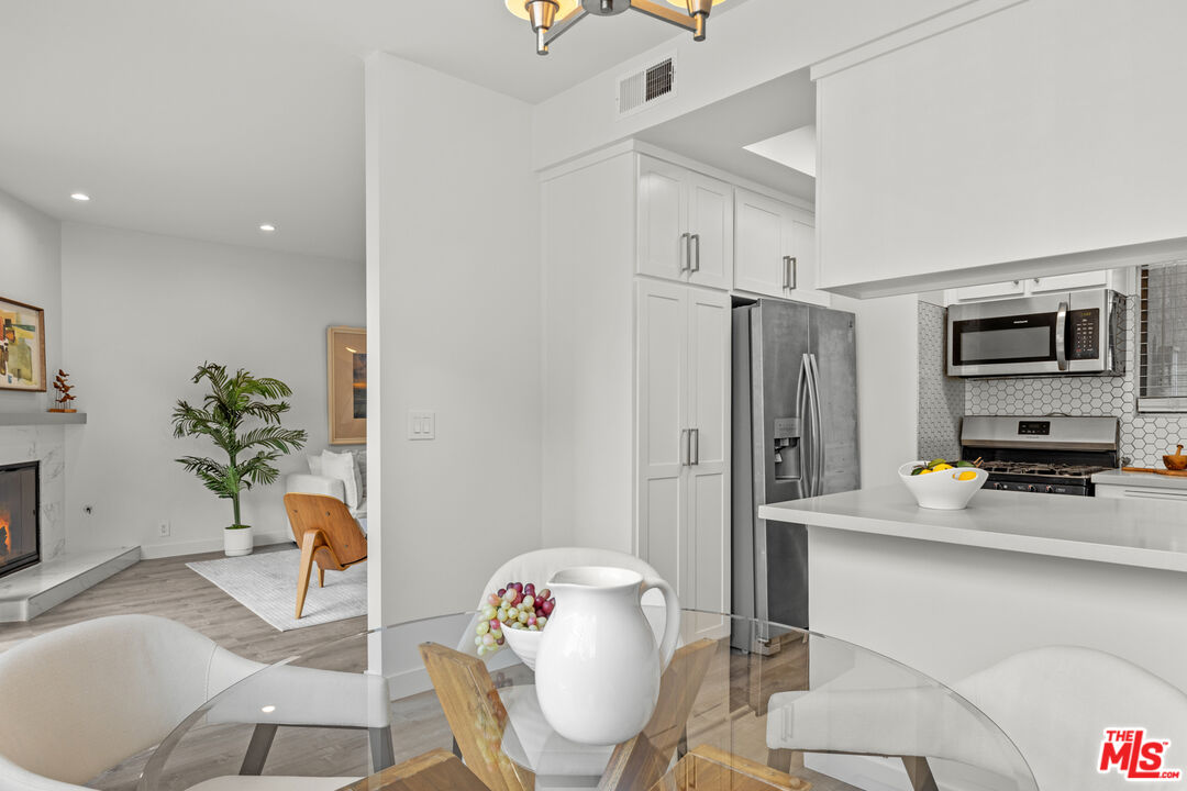 8110 Manitoba Street, Unit 106 Playa del Rey, CA 90293 - Photo 4 of 20 a kitchen with stainless steel appliances a refrigerator and a dining table