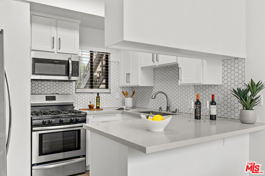 8110 Manitoba Street, Unit 106 Playa del Rey, CA 90293 - Photo 6 of 20 a kitchen with a sink a stove and cabinets