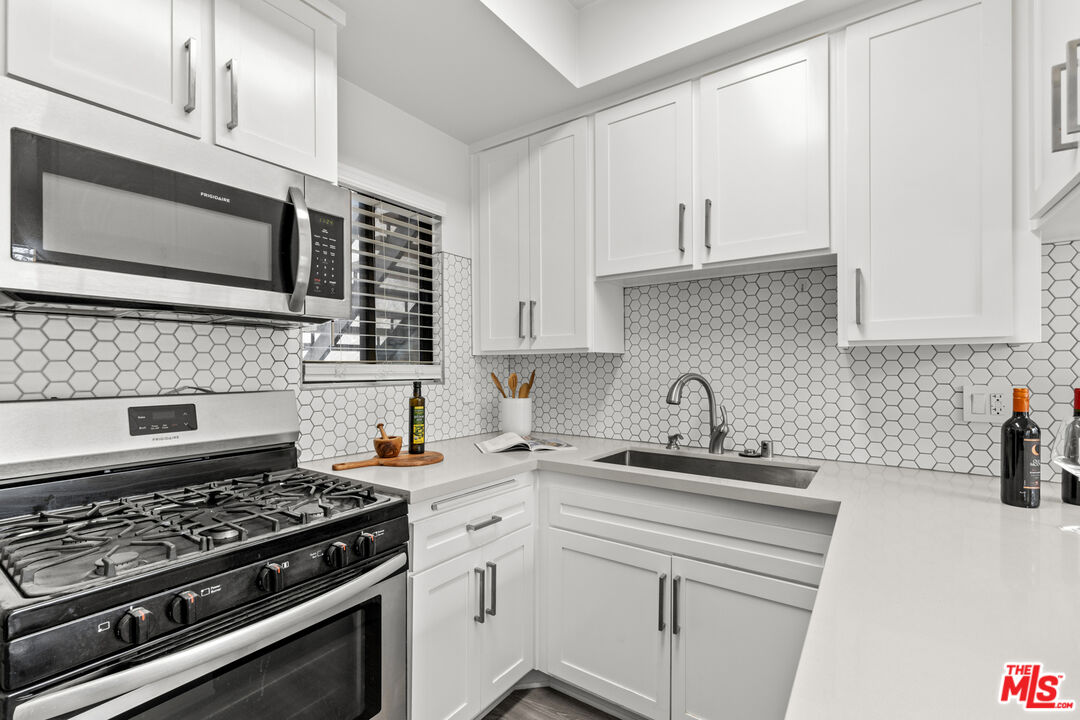 8110 Manitoba Street, Unit 106 Playa del Rey, CA 90293 - Photo 7 of 20 a kitchen with stainless steel appliances a sink a stove and cabinets