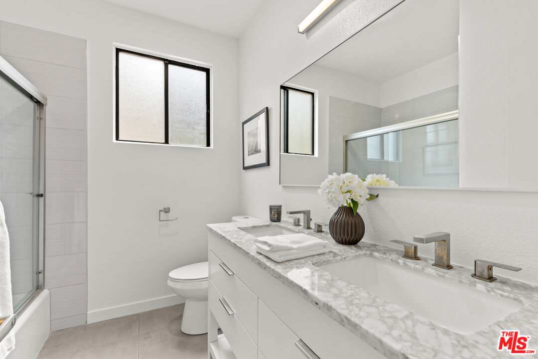 8110 Manitoba Street, Unit 106 Playa del Rey, CA 90293 - Photo 8 of 20 a bathroom with a granite countertop toilet sink and mirror