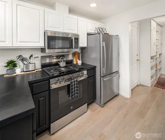 a kitchen with granite countertop a refrigerator stove and microwave