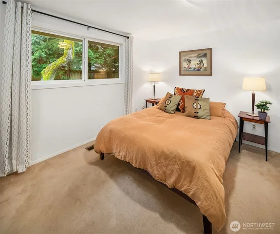 a bed sitting in a bedroom next to a window