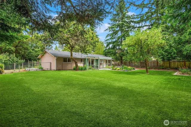 a view of an house with backyard and a tree