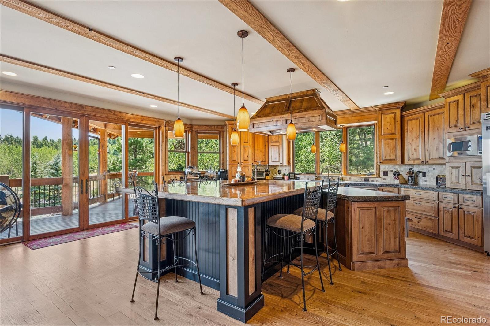 477 West Meadow Road Evergreen, CO 80439 - Photo 12 of 50 a dining room with wooden floor a glass table and chairs