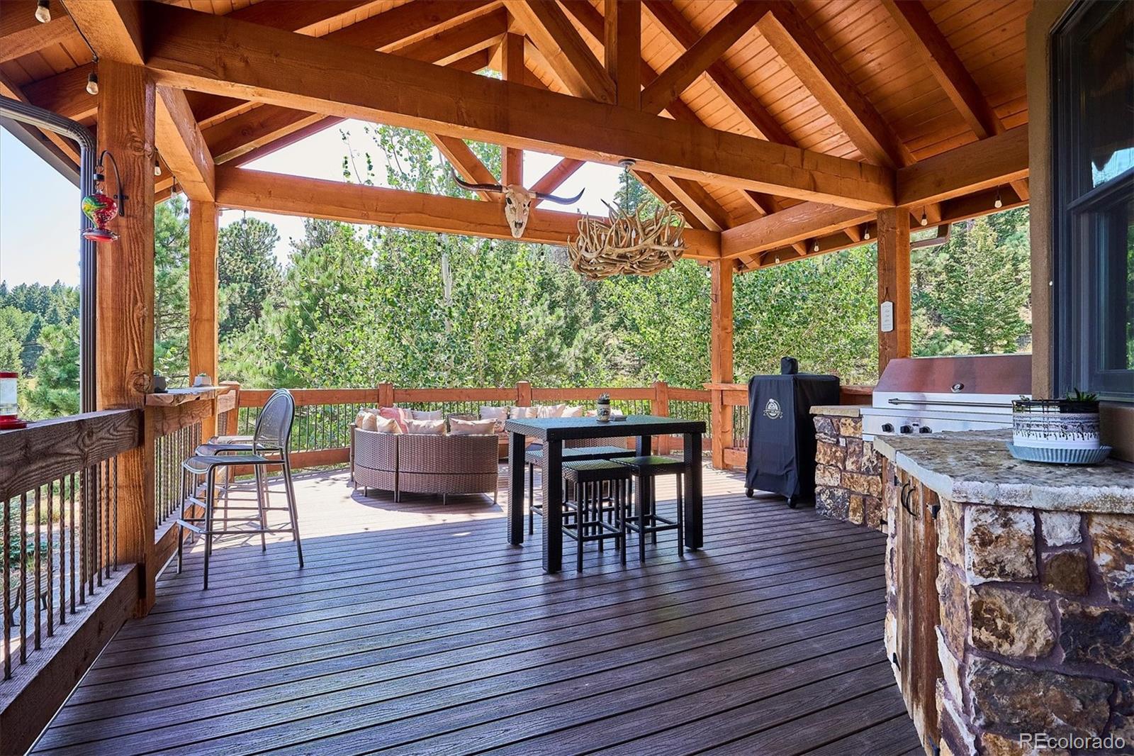 477 West Meadow Road Evergreen, CO 80439 - Photo 17 of 50 a view of a patio with a table chairs and wooden floor