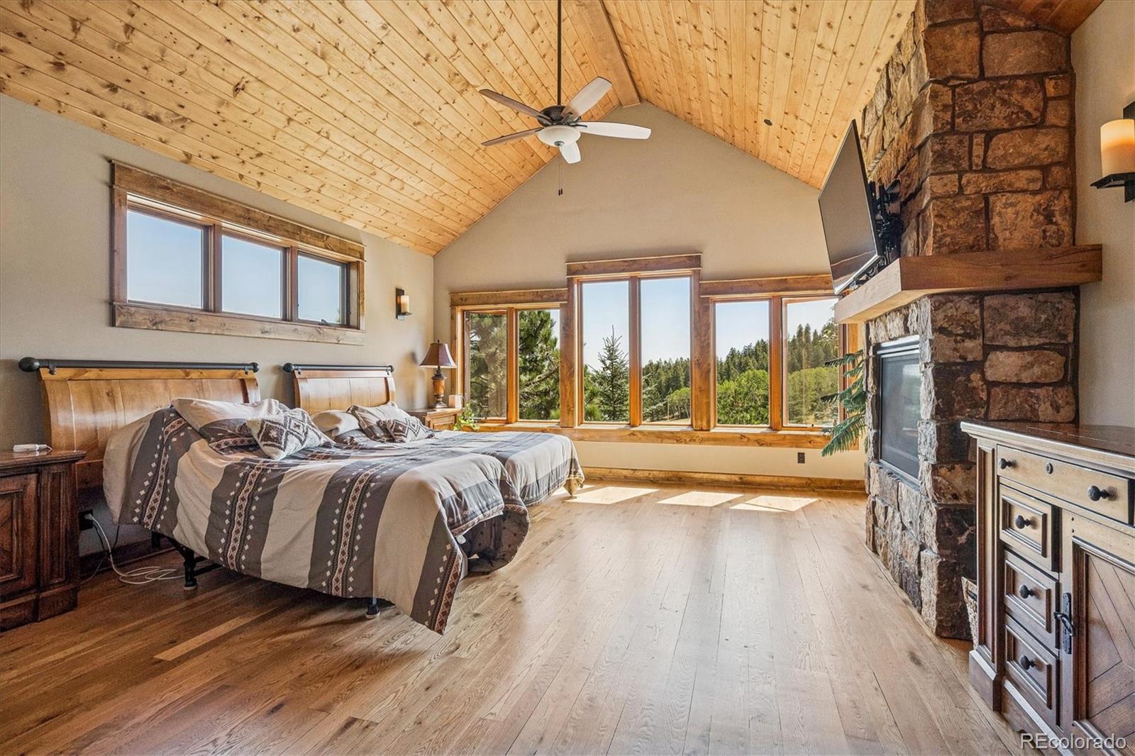 477 West Meadow Road Evergreen, CO 80439 - Photo 20 of 50 a spacious bedroom with a large bed and a large window