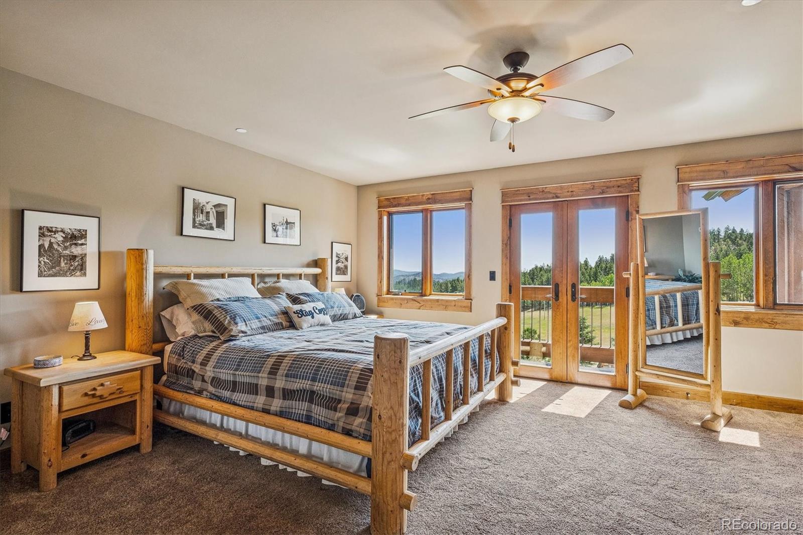477 West Meadow Road Evergreen, CO 80439 - Photo 24 of 50 a bedroom with a bed a ceiling fan and a large window