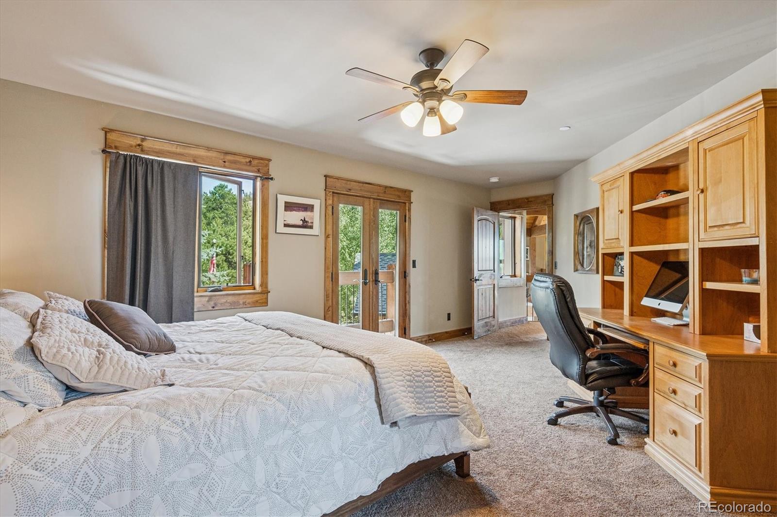 477 West Meadow Road Evergreen, CO 80439 - Photo 28 of 50 a bedroom with a large bed and a chandelier