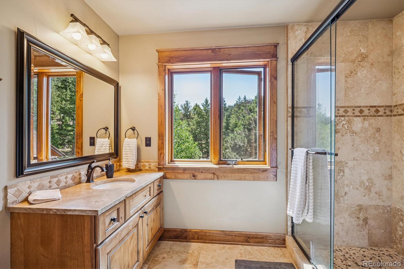 477 West Meadow Road Evergreen, CO 80439 - Photo 29 of 50 a bathroom with a granite countertop sink and a window