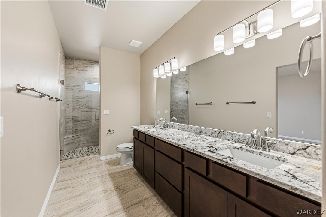 9818 North Cyrus Road Kingman, AZ 86401 - Photo 18 of 42 a bathroom with a granite countertop sink a mirror and a shower