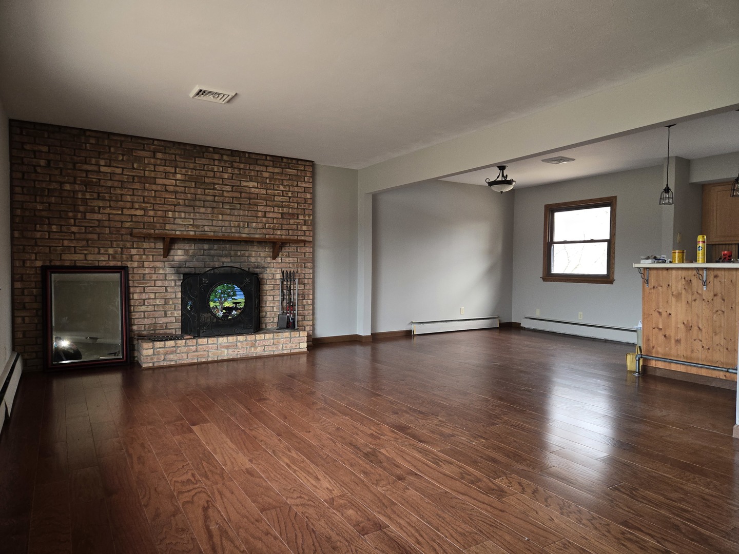 1309 Crest Lane Rochelle, IL 61068 - Photo 5 of 18 a view of an empty room with wooden floor fireplace and a window