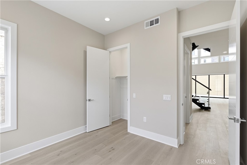 156 Apron Irvine, CA 92618 - Photo 11 of 40 an empty room with wooden floor and windows