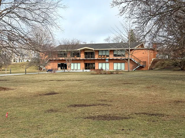 a front view of residential houses with yard and trees
