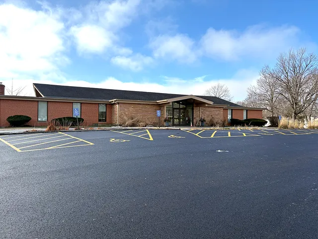 a front view of a house with a yard and parking