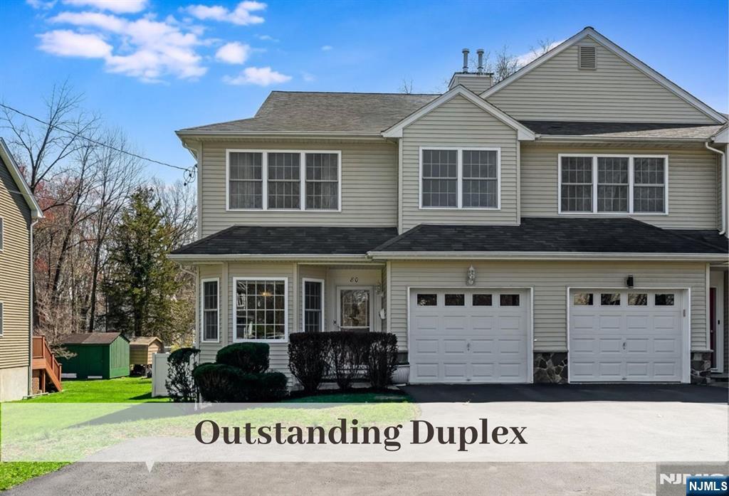 a view of a white house with large windows and a yard