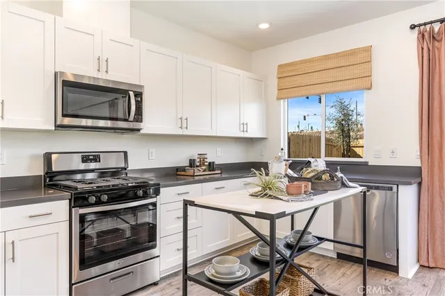a kitchen with stainless steel appliances kitchen island granite countertop a stove a sink and a microwave