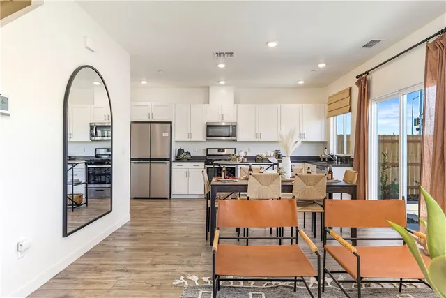 a kitchen with stainless steel appliances kitchen island granite countertop a refrigerator and chairs