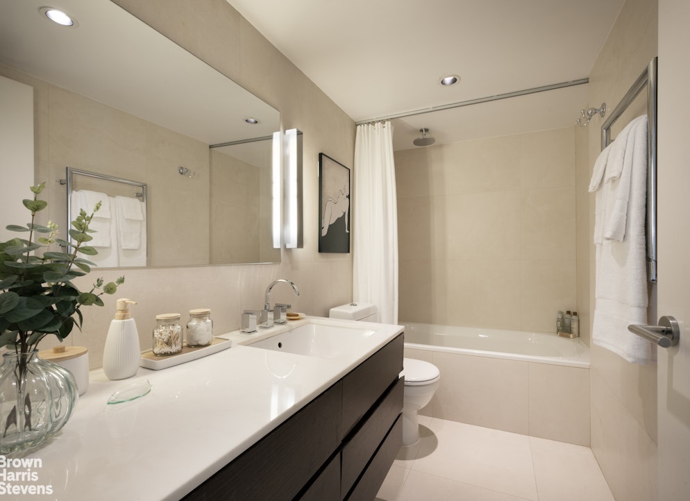 27 East 65th Street, Unit 11D Manhattan, NY 10065 - Photo 11 of 15 a bathroom with a sink a toilet and a large mirror