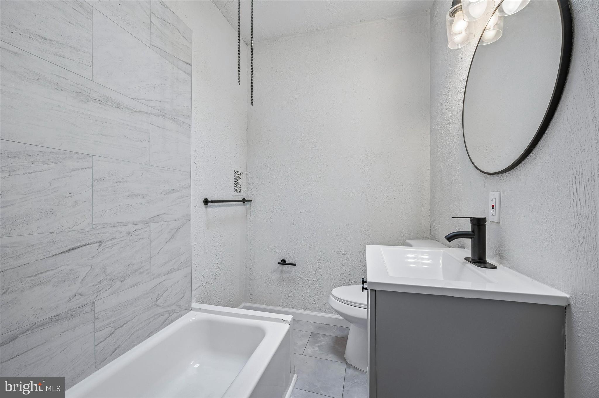 2433 South Millick Street Philadelphia, PA 19142 - Photo 13 of 15 a bathroom with a sink a toilet and a mirror