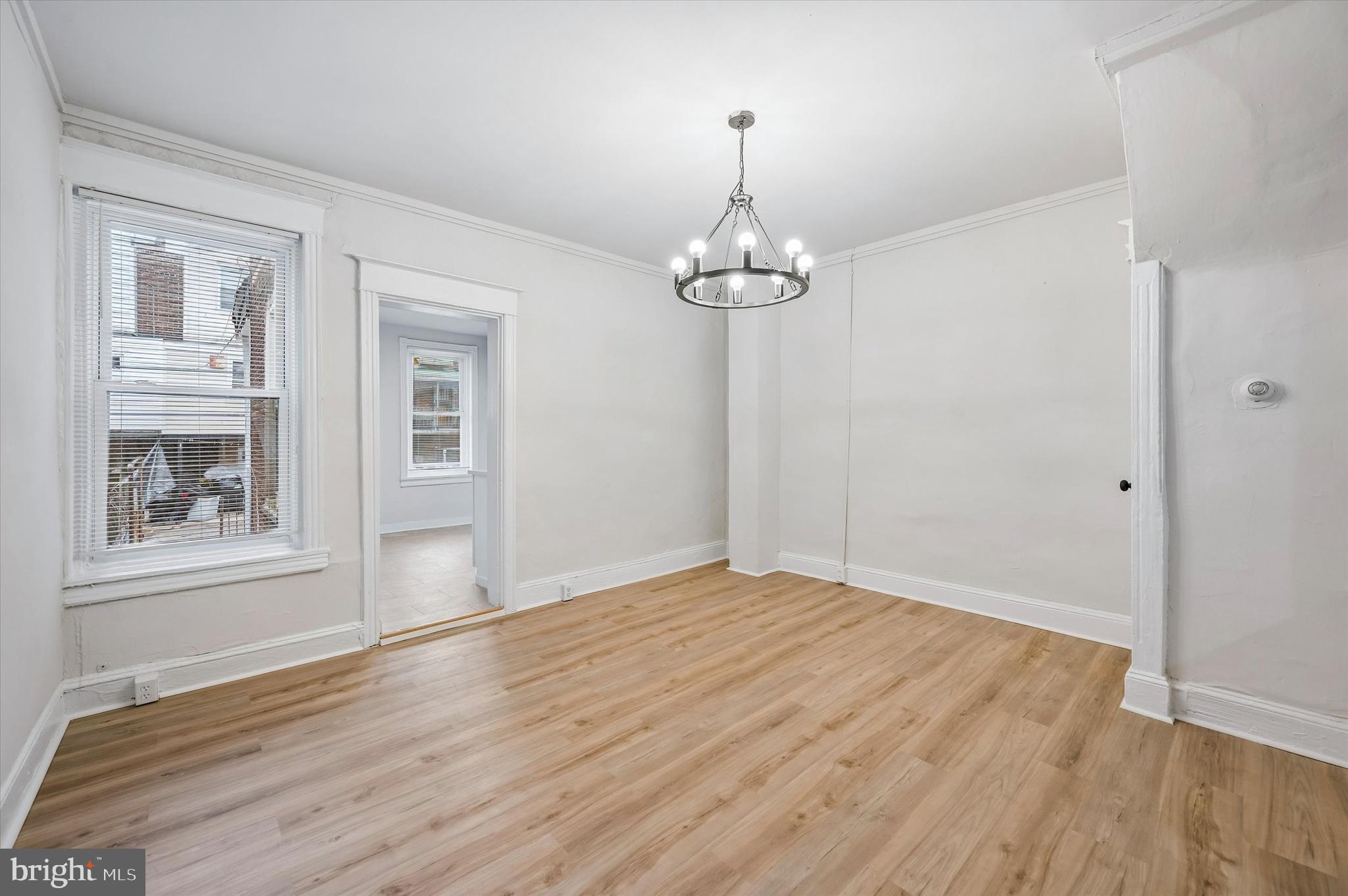2433 South Millick Street Philadelphia, PA 19142 - Photo 5 of 15 a view of empty room with wooden floor and chandelier