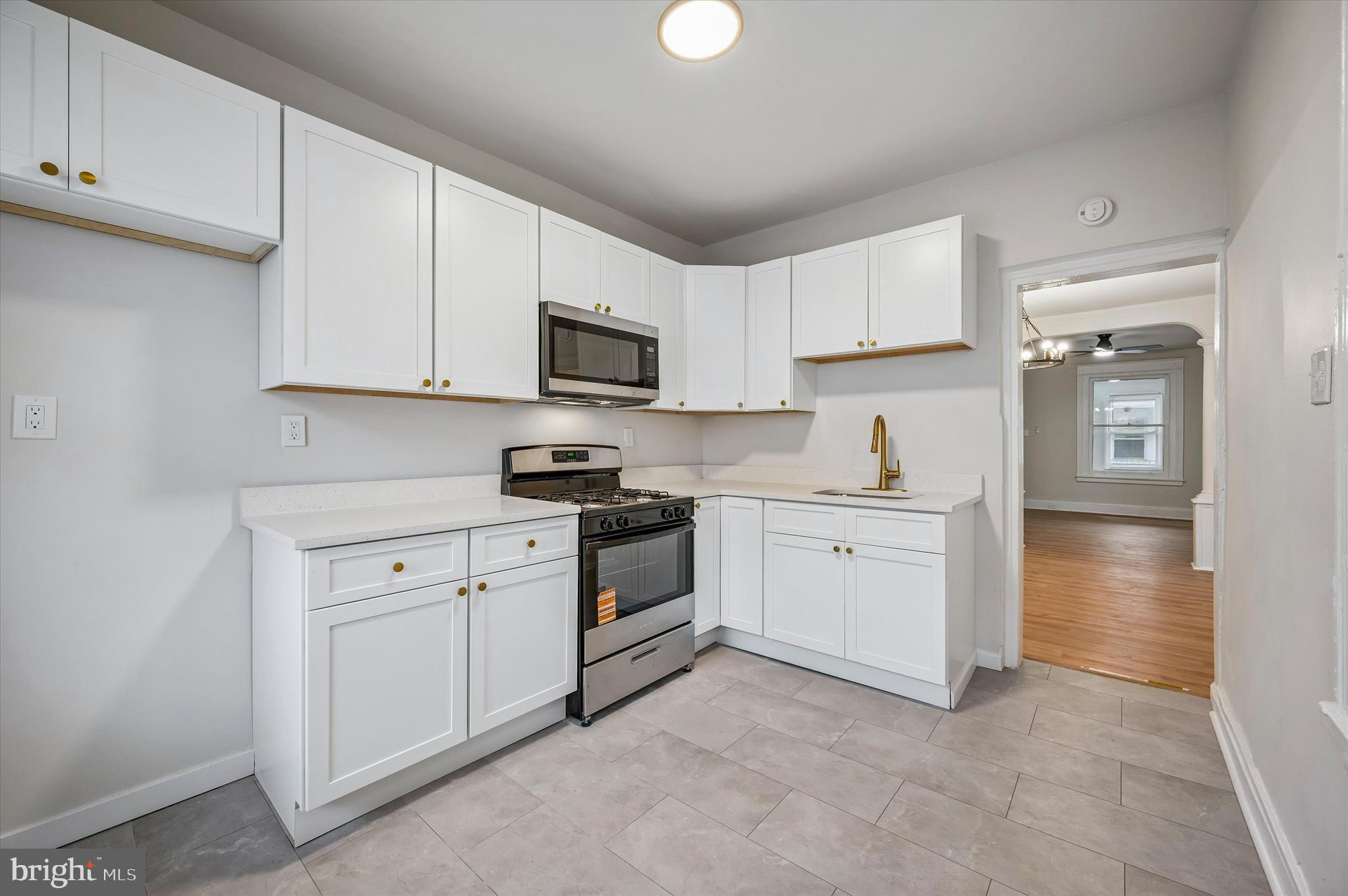 2433 South Millick Street Philadelphia, PA 19142 - Photo 8 of 15 a kitchen with white cabinets and white appliances