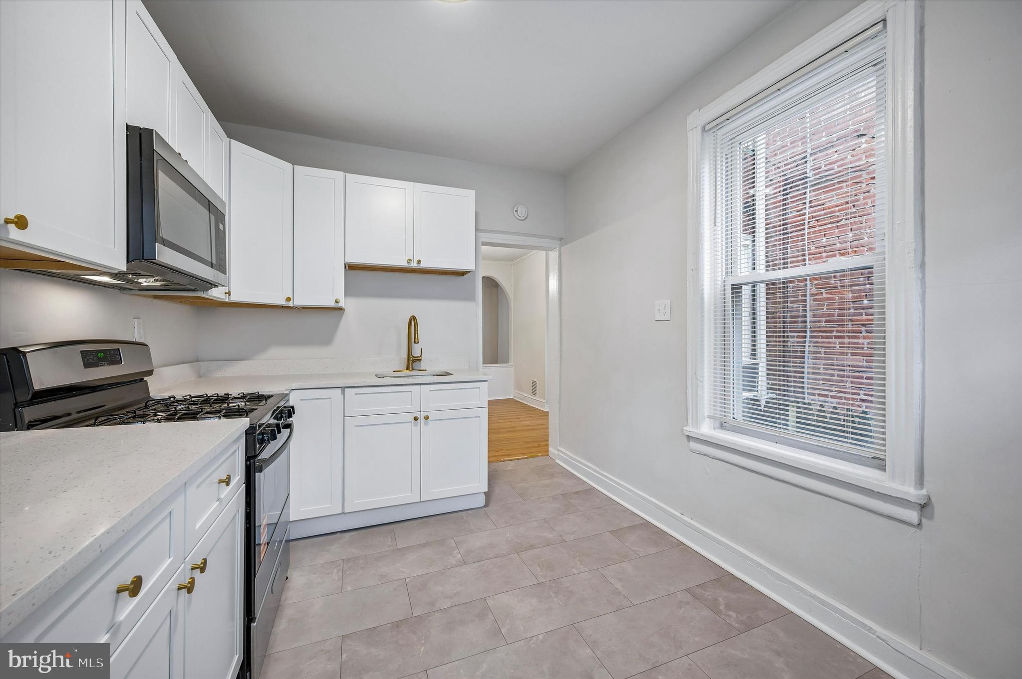 2433 South Millick Street Philadelphia, PA 19142 - Photo 9 of 15 a kitchen with stainless steel appliances granite countertop a stove a sink and a microwave