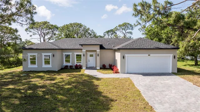 a front view of a house with a garden and yard