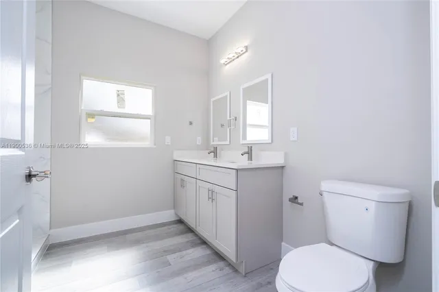 a bathroom with a toilet sink and mirror