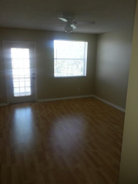 7434 Michigan Isle Road Lake Worth, FL 33467 - Photo 13 of 23 an empty room with wooden floor and windows
