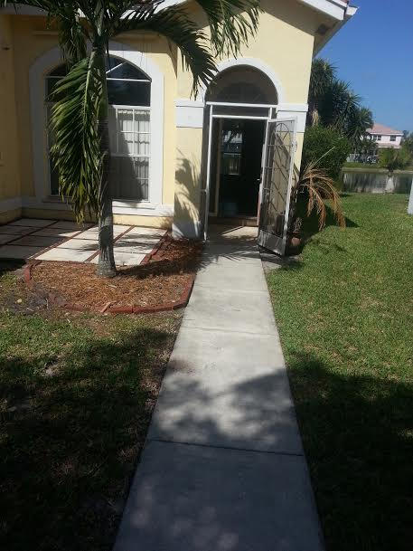 7434 Michigan Isle Road Lake Worth, FL 33467 - Photo 18 of 23 a front view of a house with garden