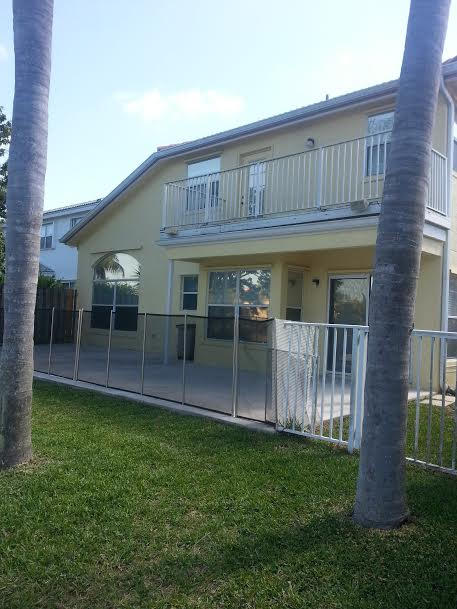 7434 Michigan Isle Road Lake Worth, FL 33467 - Photo 20 of 23 a view of house with a big yard and large wooden fence