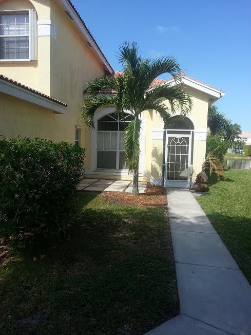 7434 Michigan Isle Road Lake Worth, FL 33467 - Photo 2 of 23 a front view of a house with a yard