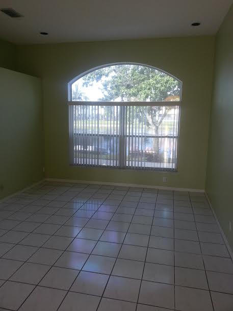 7434 Michigan Isle Road Lake Worth, FL 33467 - Photo 5 of 23 an empty room with wooden floor and a window