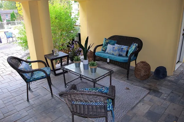 a view of a patio with couches table and chairs and potted plants