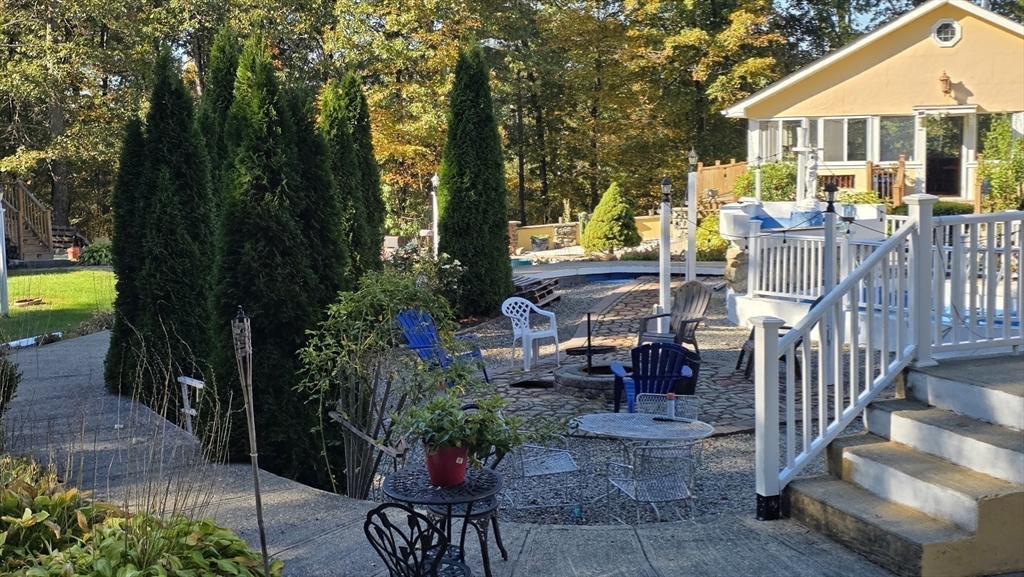 85 Burlingame Road, Unit 1 Charlton, MA 01507 - Photo 27 of 31 a view of a patio with couches table and chairs and potted plants