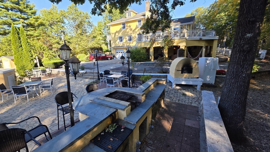 85 Burlingame Road, Unit 1 Charlton, MA 01507 - Photo 28 of 31 a view of a patio with dining table and chairs with wooden floor and fence
