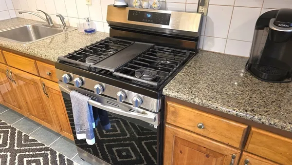 a stove top oven sitting inside of a kitchen