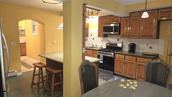 a kitchen with stainless steel appliances granite countertop a refrigerator a stove top oven a sink and dishwasher