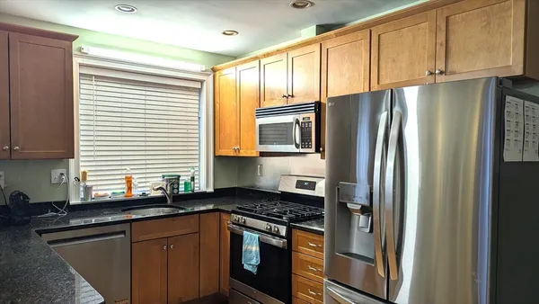 a kitchen with stainless steel appliances granite countertop a refrigerator stove and sink