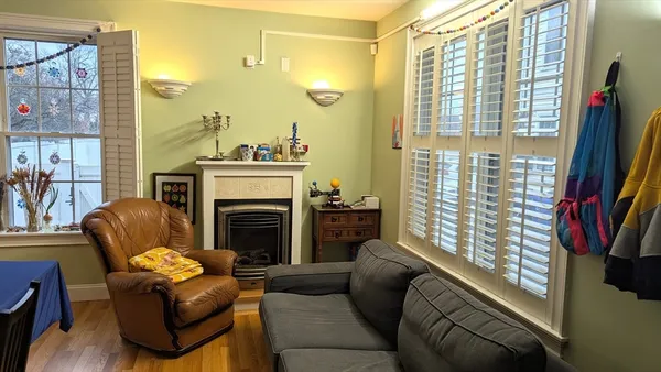 a living room with furniture a large window and a fireplace