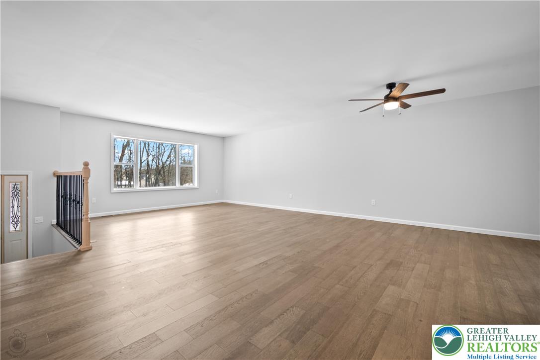1111 Delabole Jct Road Pen Argyl, PA 18072 - Photo 12 of 26 an empty room with wooden floor chandelier fan and windows
