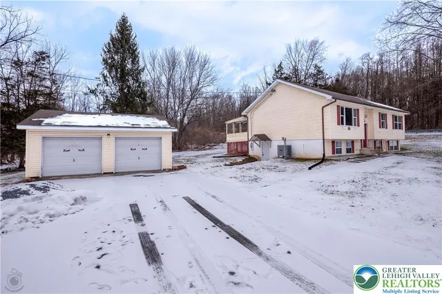 a view of a white house with a yard covered in snow