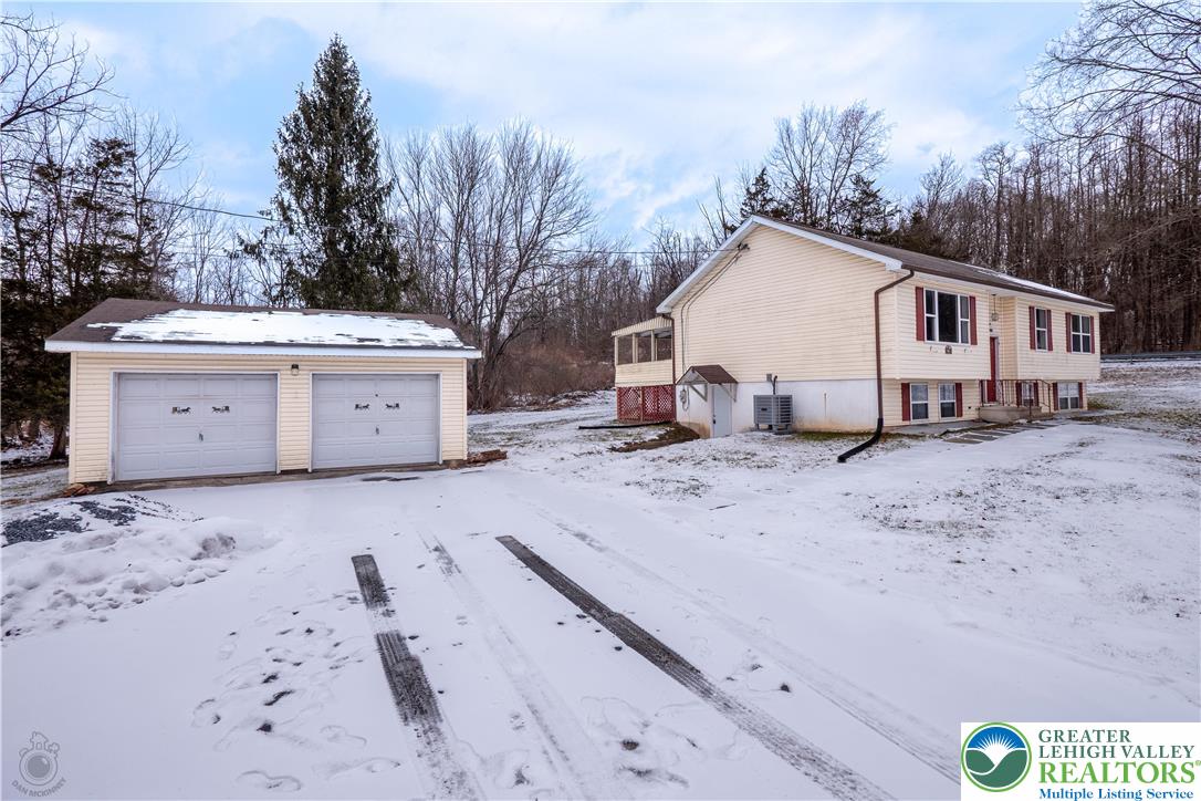1111 Delabole Jct Road Pen Argyl, PA 18072 - Photo 3 of 26 a view of a white house with a yard covered in snow