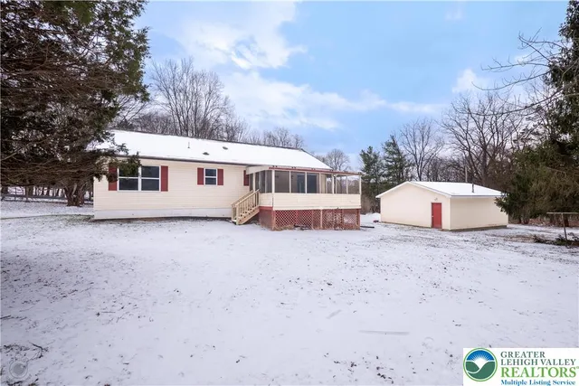 a view of a house with a backyard and trees
