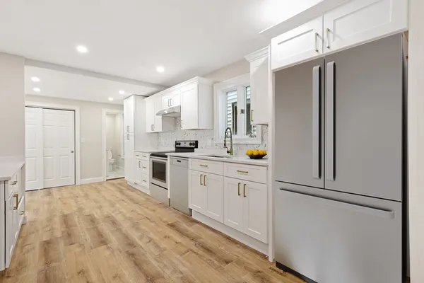 a kitchen with stainless steel appliances a refrigerator sink and stove