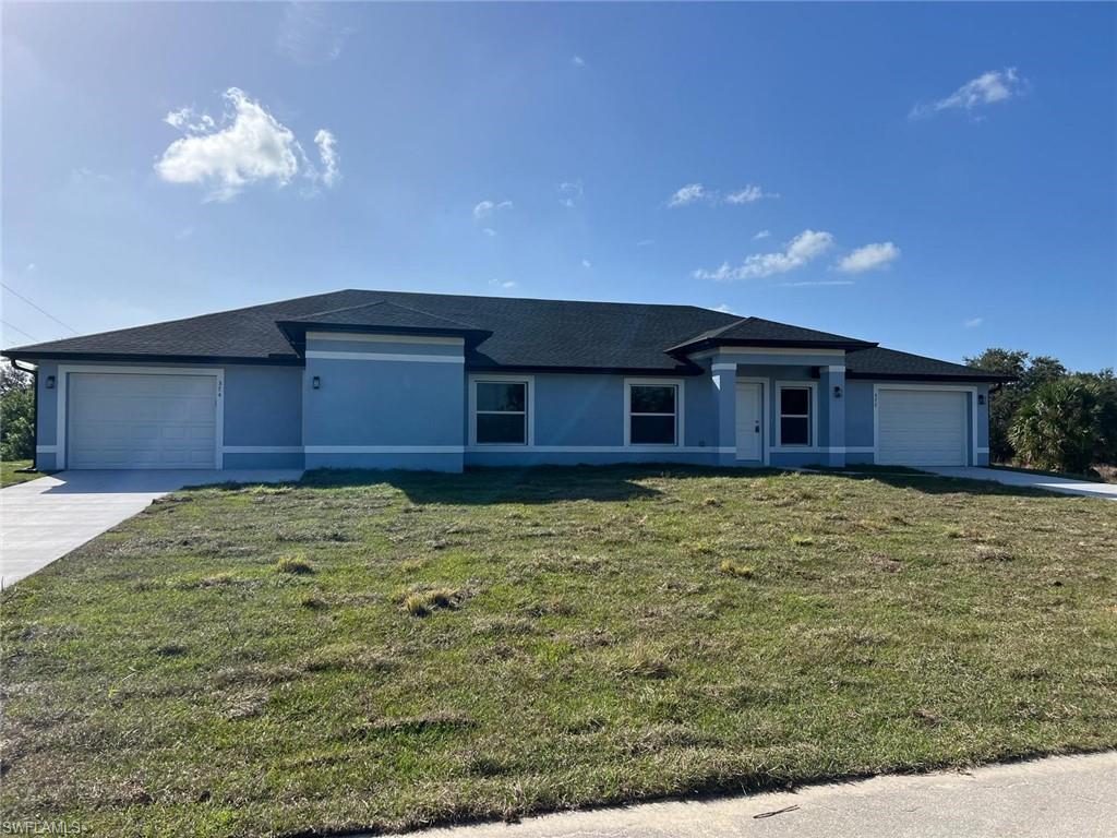 374 Compese Avenue South Lehigh Acres, FL 33974 - Photo 2 of 15 a front view of a house with a yard
