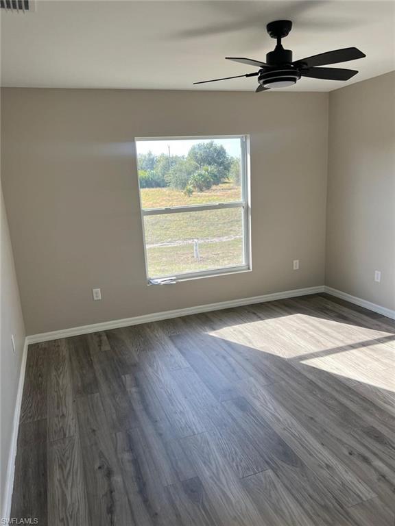 374 Compese Avenue South Lehigh Acres, FL 33974 - Photo 6 of 15 an empty room with wooden floor fan and windows