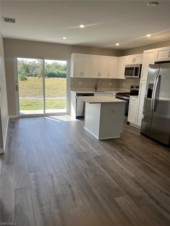 374 Compese Avenue South Lehigh Acres, FL 33974 - Photo 9 of 15 a large kitchen with stainless steel appliances granite countertop a stove a sink a refrigerator with wooden floors and cabinets