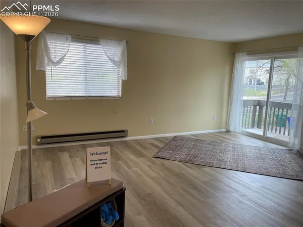 a view of a room with wooden floor and a window